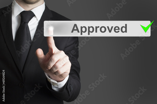 businessman pushing button approved green authorized