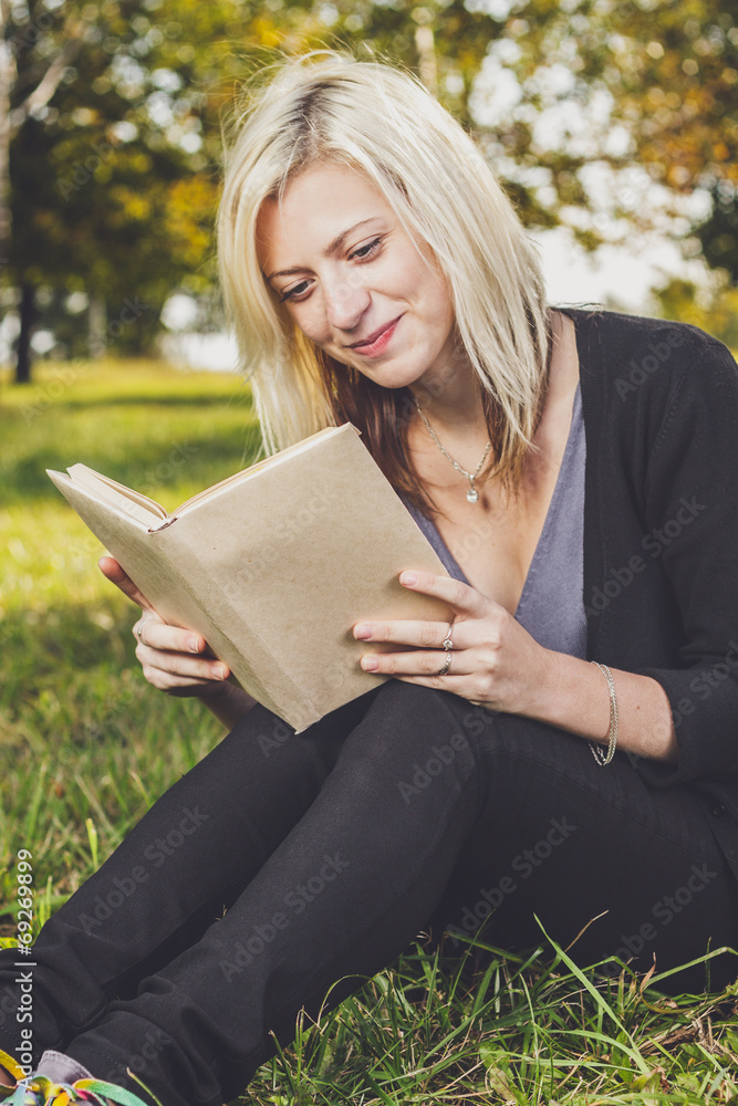 girl reading in park on grass girl reading in park on grass