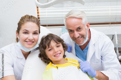 Pediatric dentist assistant and little boy all smiling at camera