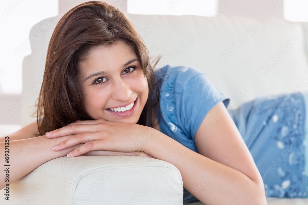 Pretty brunette smiling at camera on the couch Pretty brunette smiling at camera on the couch