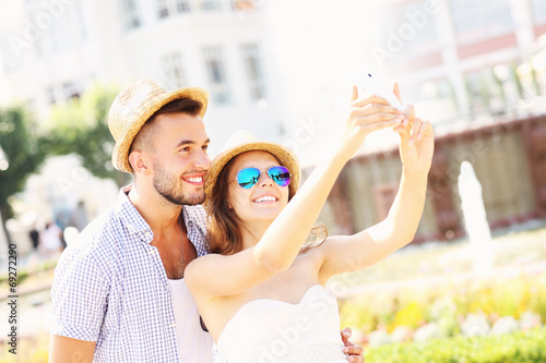 Happy couple taking selfie in the park