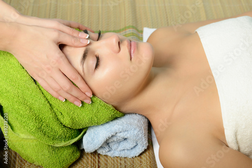 Young beautiful woman in spa gets a facial massage