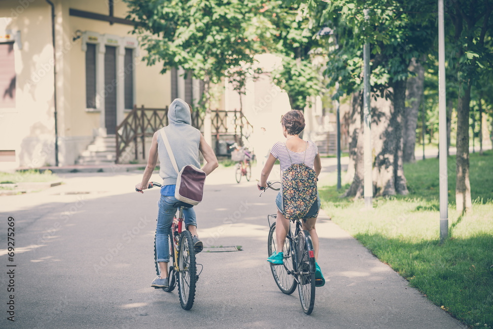 Fototapeta premium couple of friends young man and woman riding bike