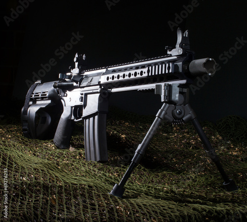 AR-15 pistol on green netting with a dark background photo