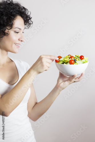 Young woman profile with vegetable salad isolated in white