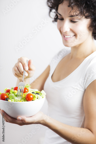 Young woman & vegetable salad isolated in white