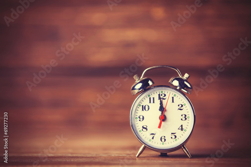 Retro alarm clock on wooden background