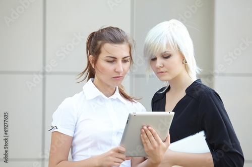 Two business woman with tablets