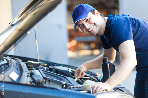 Professional car mechanic working in auto repair service. photo