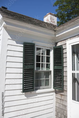 White Cape Cod house with green shutters in Massachusetts © cindygoff