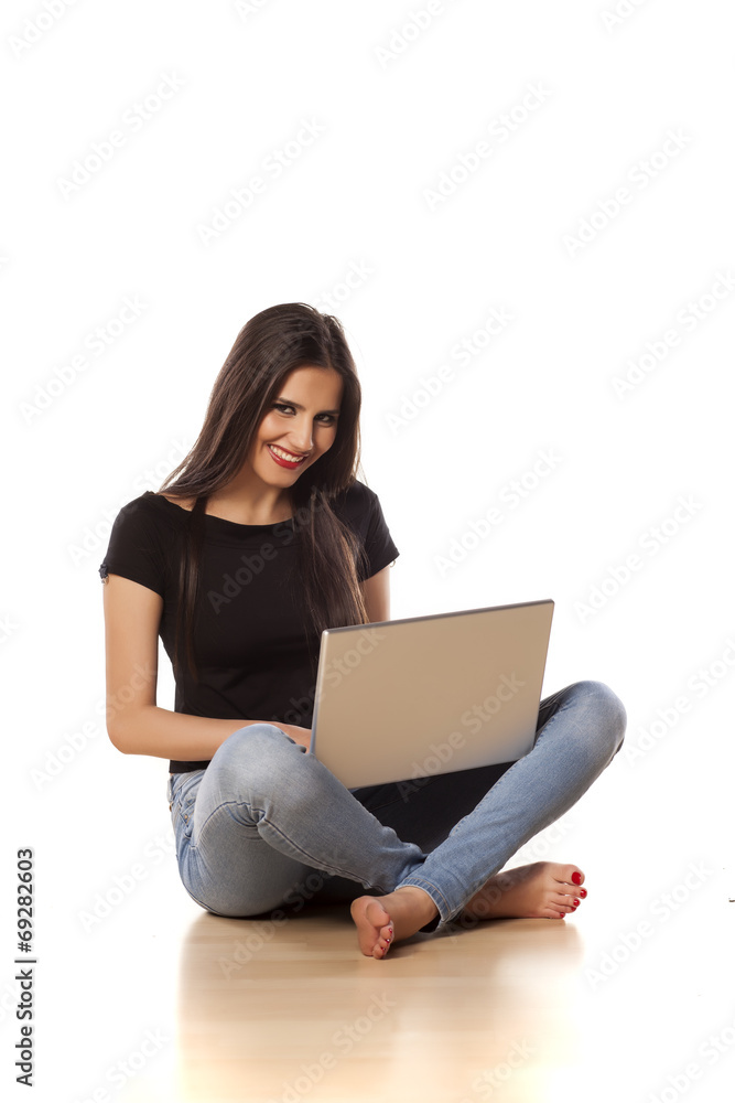 smiling girl sitting on the floor and working on laptop smiling girl sitting on the floor and working on laptop