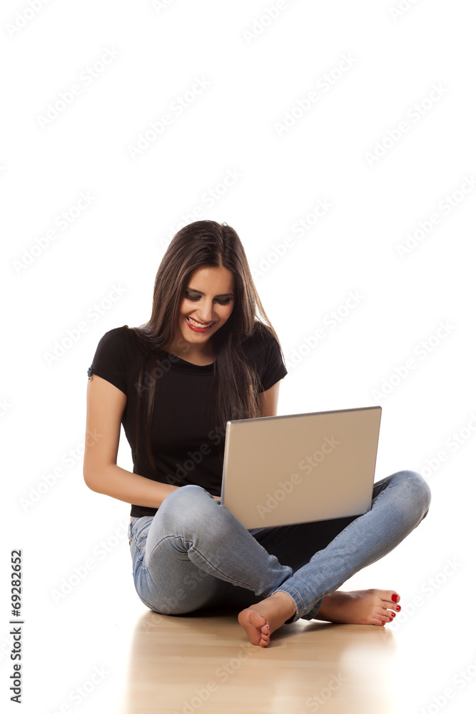 smiling girl sitting on the floor and working on laptop smiling girl sitting on the floor and working on laptop