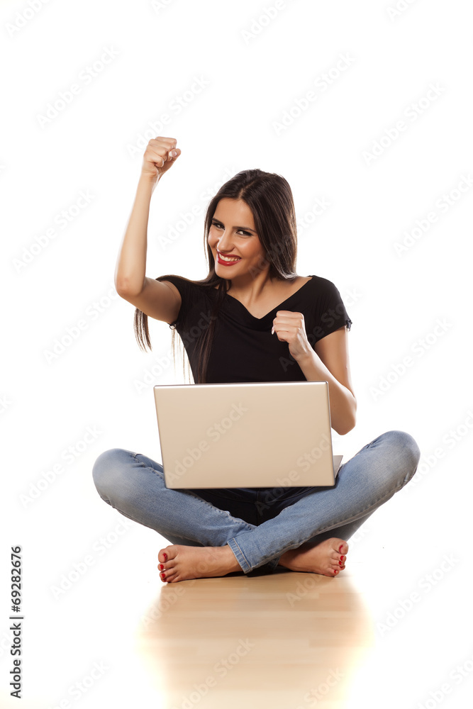 happy girl with the winning gesture working on laptop happy girl with the winning gesture working on laptop