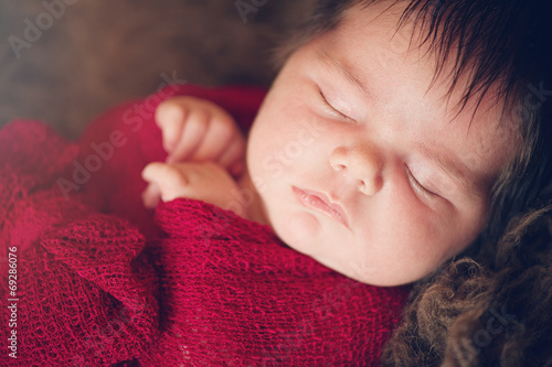 Profile of Sleeping Newborn Baby in Red Wrap