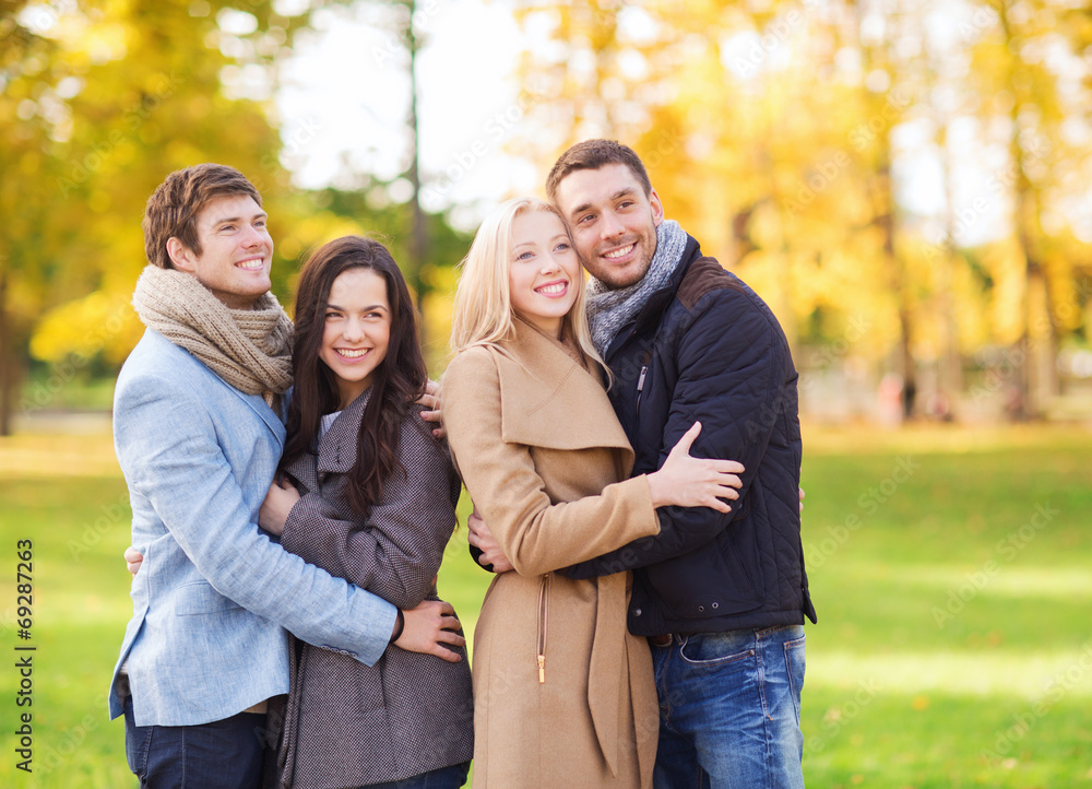 group of smiling men and women in autumn park group of smiling men and women in autumn park