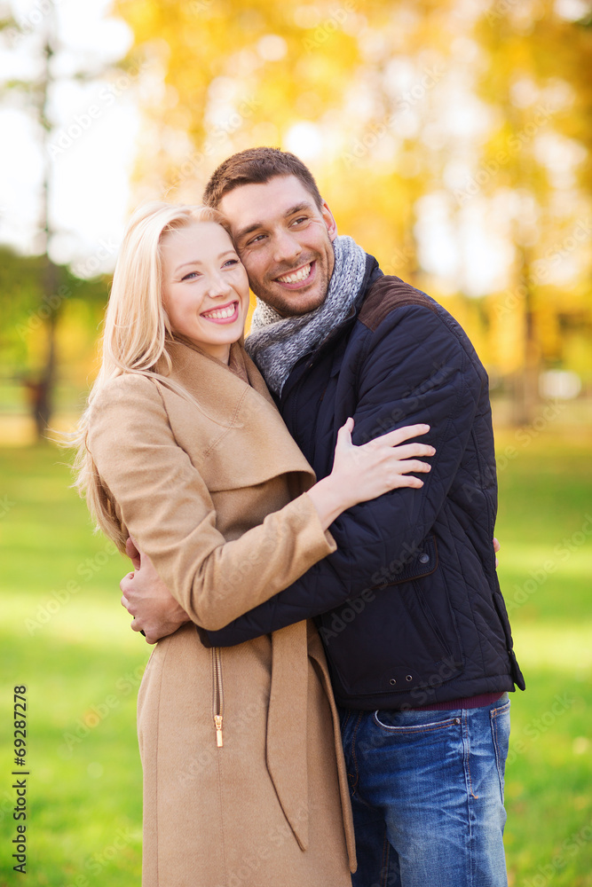 smiling couple hugging in autumn park smiling couple hugging in autumn park