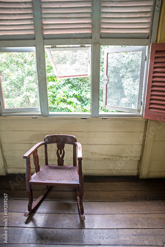 Isolated old rocking chair under several windows