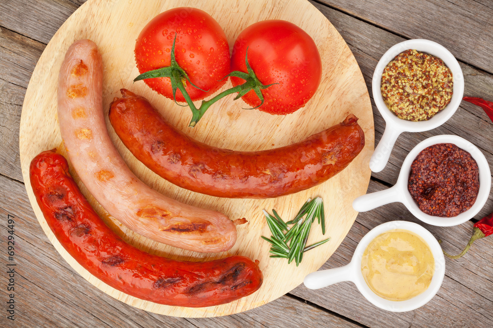 Various grilled sausages with condiments and tomatoes Various grilled sausages with condiments and tomatoes