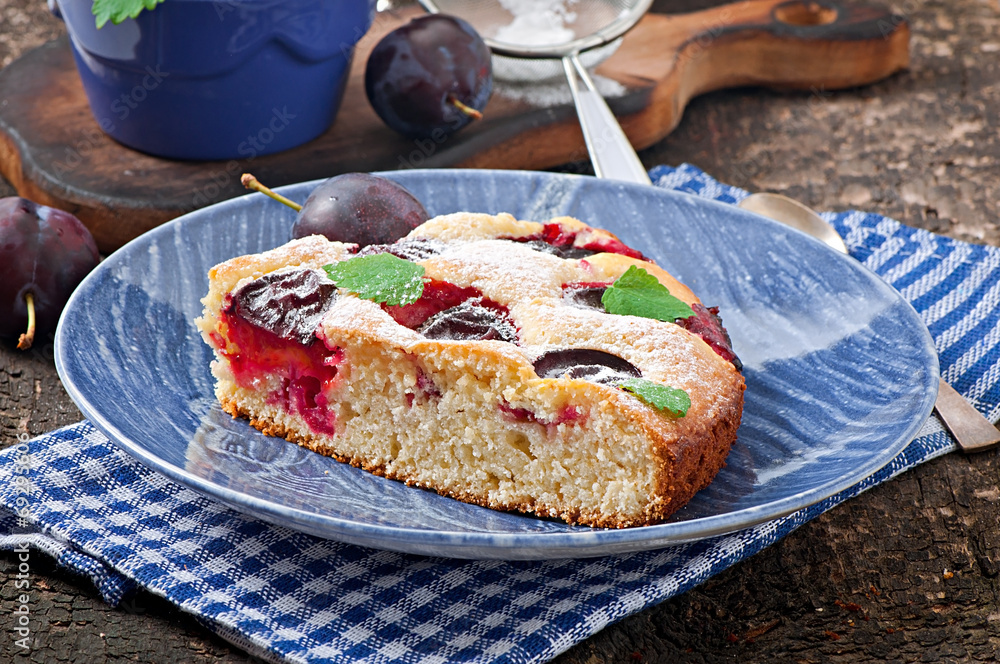 Delicious homemade cake with plums on a wooden background Delicious homemade cake with plums on a wooden background