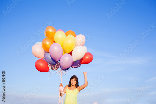 Beautiful pregnant woman girl with balloons on sky background