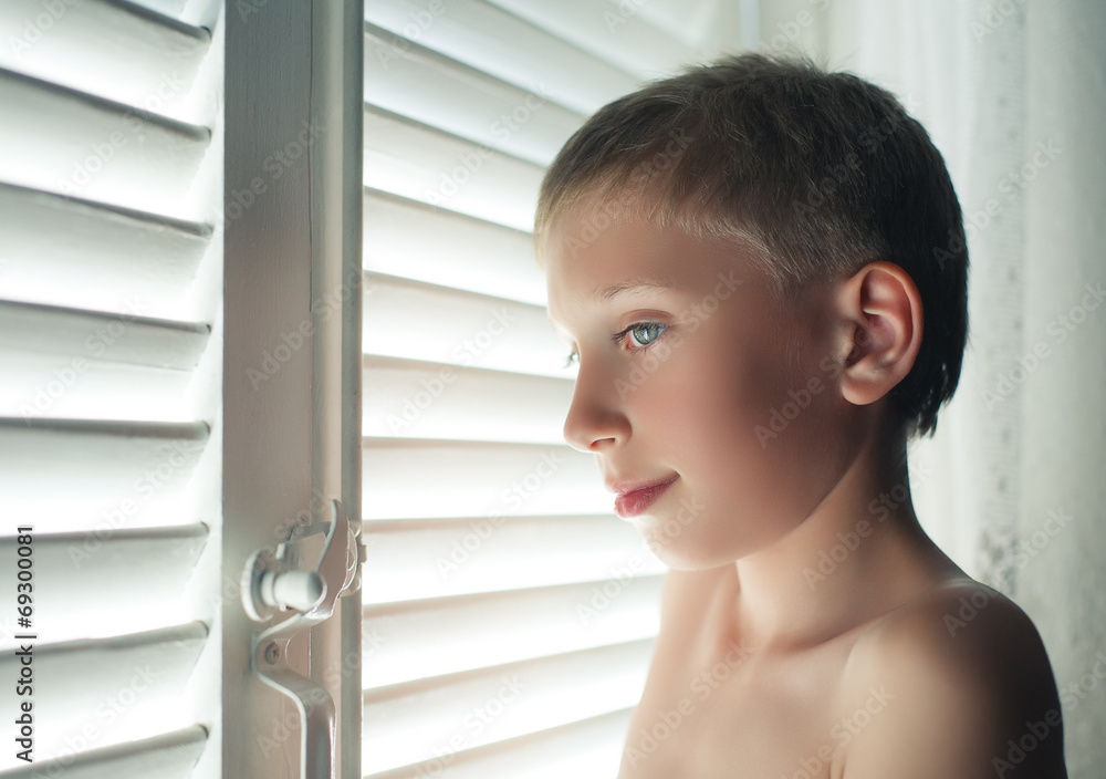 Funny boy by window with blinds. Candid portait. Funny boy by window with blinds. Candid portait.