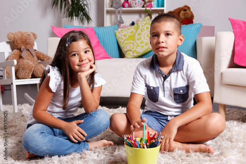 Portrait of young twin siblings in the living room