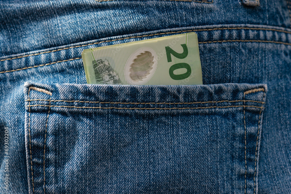 detail of New Zealand dollars in jeans pocket detail of New Zealand dollars in jeans pocket