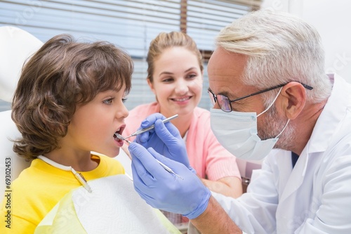 Pediatric dentist examining a boys teeth