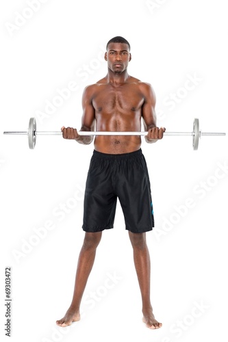 Portrait of a serious fit young man lifting barbell