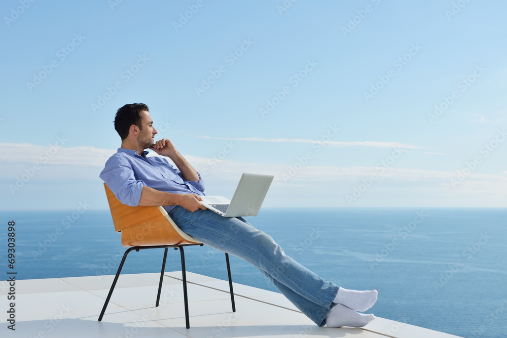 relaxed young man at home on balcony