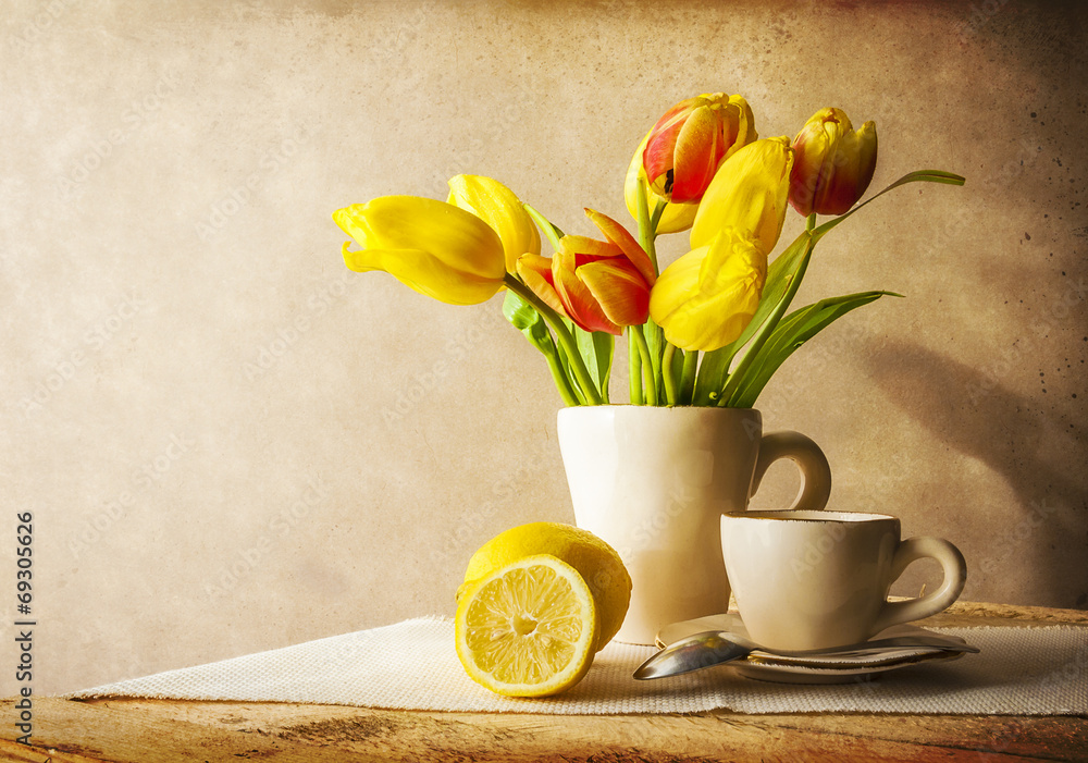 Fototapeta premium Wciąż życie bukieta tulipanów żółta filiżanka herbata