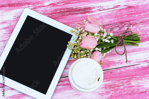 Fototapeta Naklejka Na Ścianę i Meble -  a tablet computer, a glass of coffee and  lilies of valley and t