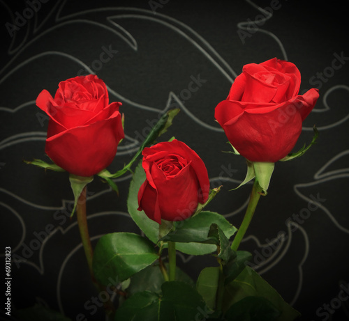 Fototapeta Naklejka Na Ścianę i Meble -  Three red roses over black backround