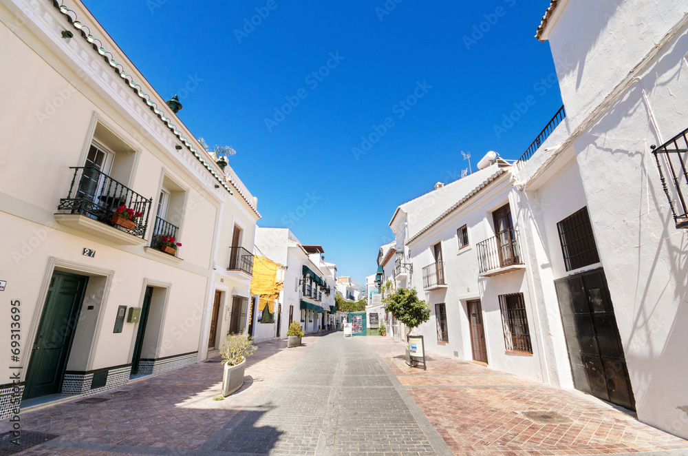 street with white houses in the village of Nerja, Spain.