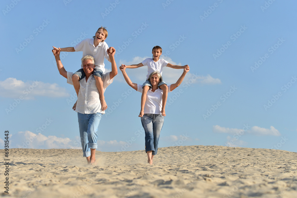 Boys with grandparents sitting on sand Boys with grandparents sitting on sand