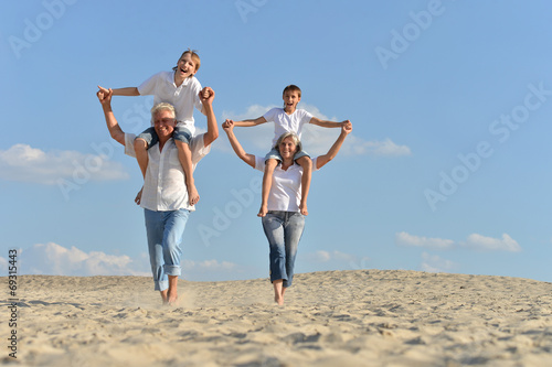 Boys with grandparents sitting on sand