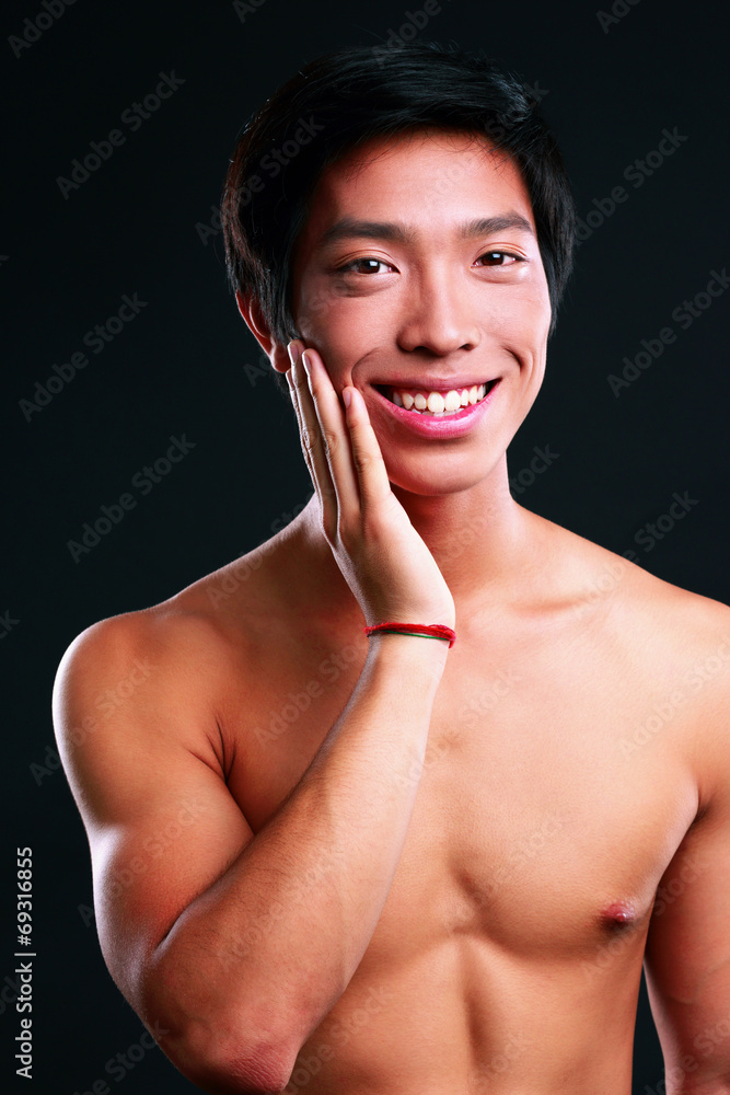 Obraz premium Portrait of a cheerful asian man standing on black background
