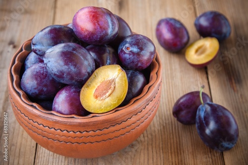 organic ripe plums in a clay bowl