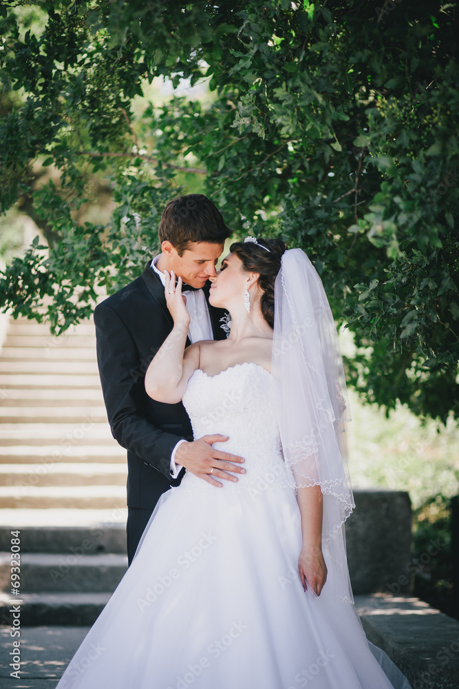 Fototapeta premium Happy bride and groom posing in a park