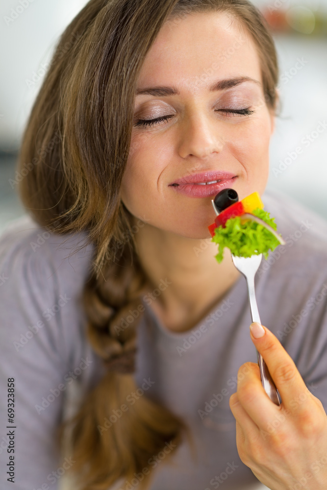 Portrait of happy young housewife eating vegetables Portrait of happy young housewife eating vegetables