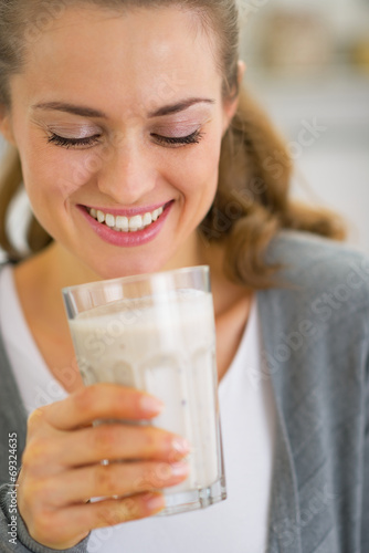 Portrait of happy young woman drinking fresh smoothie