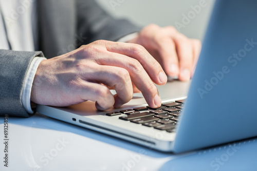 Hands of a man working with laptop