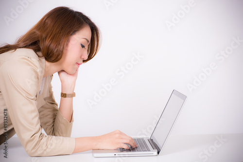 Portrait of a young business woman using laptop at office © Nonwarit