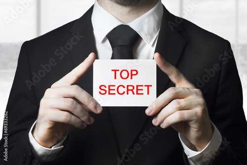 businessan holding sign top secret
