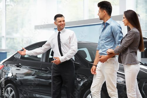 Car Salesman Invites Customers at Showroom.