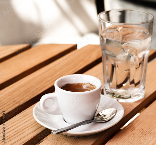 White espresso cup and glass of cold water