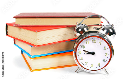 Alarm clock and multi-coloured books.