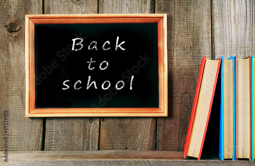 Back to school. Books on wooden background.