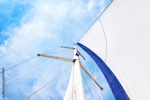 Sail and mast with sky in the background