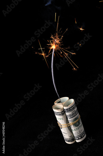 Dynamite cash with lit fuse